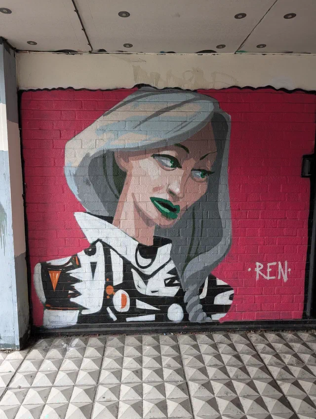 A woman with silver hair and green lipstick on a pink wall, signed Ren.