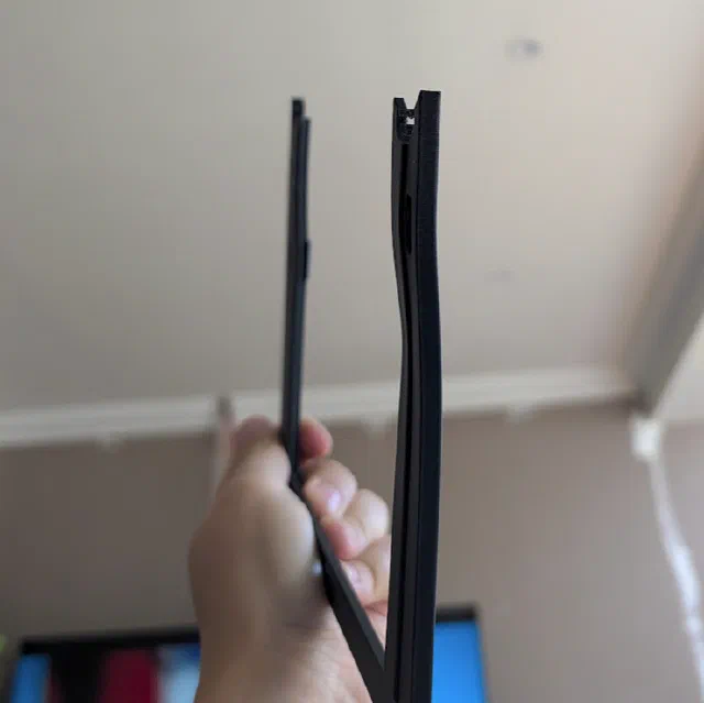 The printed mount held next to a fresh print of the same part, visibly bowed from PLA creep