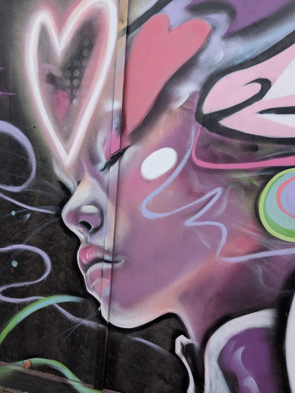 Close-up of a pink woman's face in profile, with a glowing heart outline and swirls of pink and white.